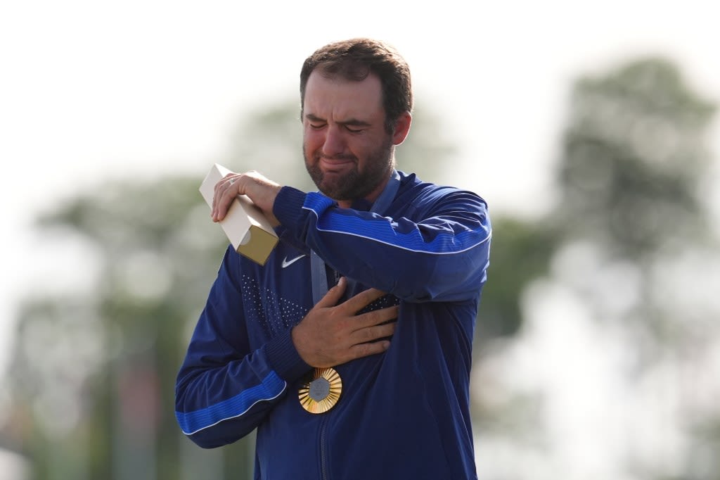 Scottie Scheffler cries during the national anthem after winning the golf gold medal at the Olympics on Aug. 4, 2024.