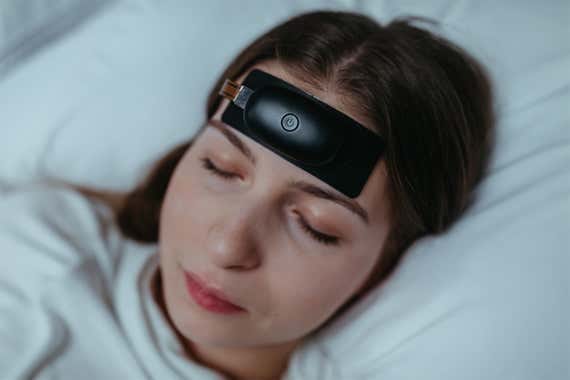 A promo image of a person wearing a myWaves device while sleeping in a bed.