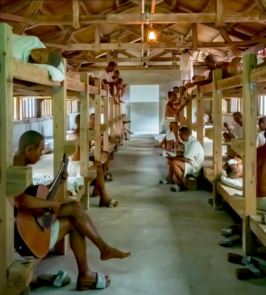 Wax figures of inmates dressed in white t-shirts and shorts fill a reconstructed dorm room at the New Life Correction Center