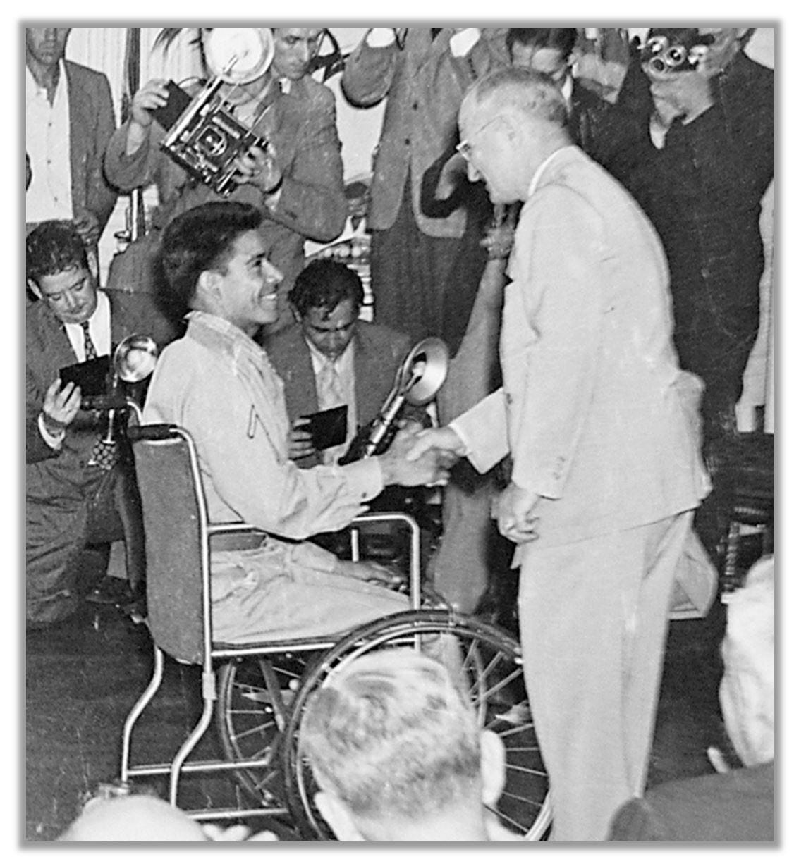 Herrera receives his Medal from Truman. He is sitting in a wheelchair.