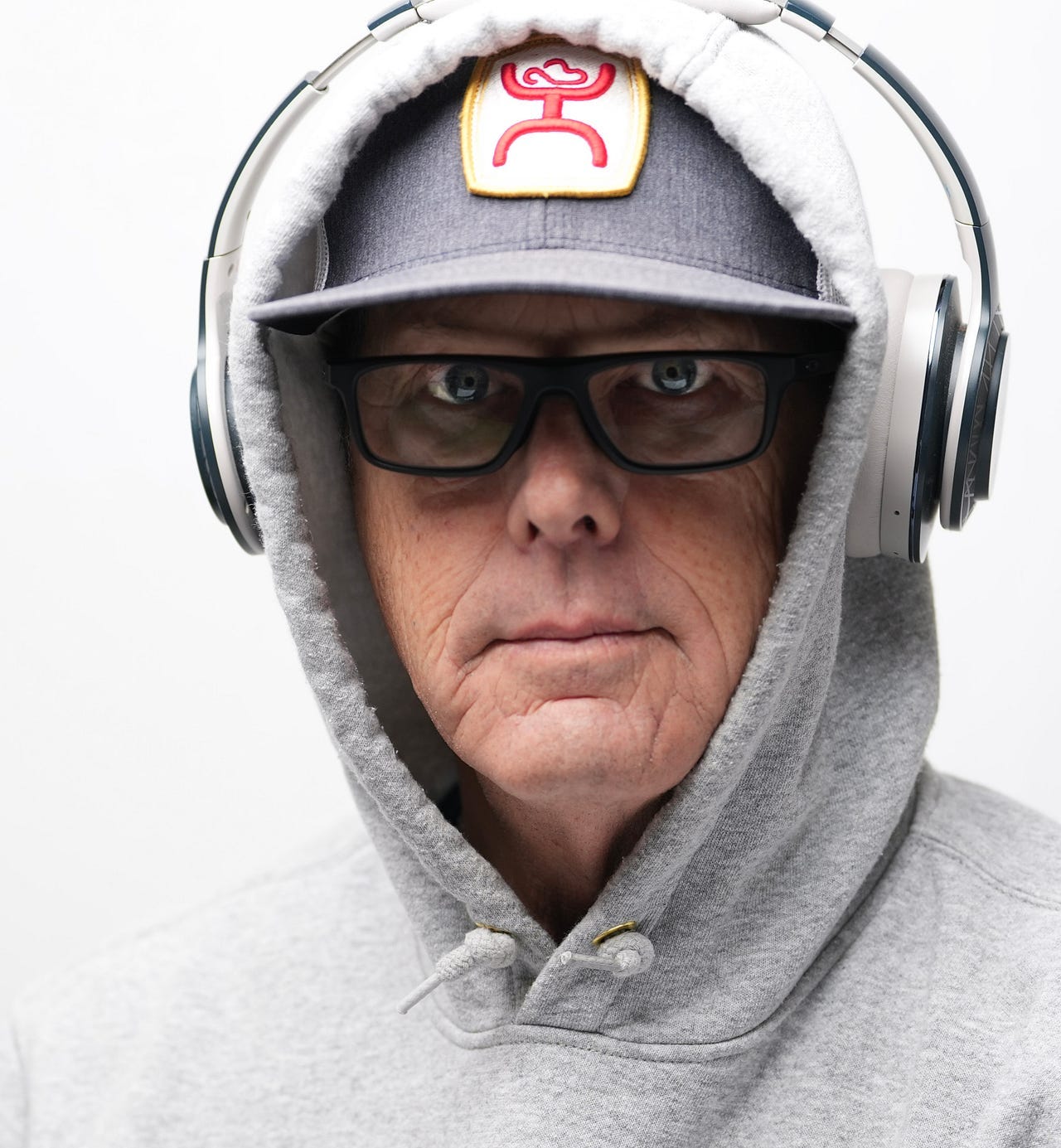Portrait of a man wearing a hoodie, baseball cap, and headshots.