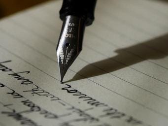 fountain pen point writing on lined paper (grant writing)