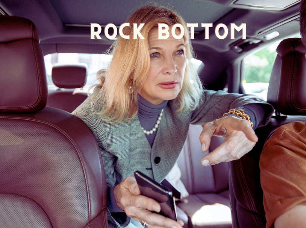 rich older blond women in pearls and blazer leaning forward from the backseat of the car telling he driver what to do by pointing her finger and squinting. The caption is ROCK BOTTOM