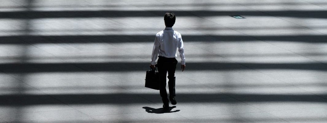man holding laptop bag walking on street man holding laptop bag walking on street