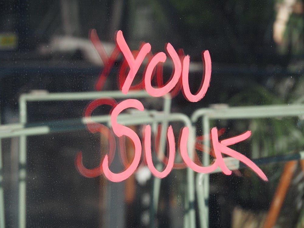 'You suck' written on a window in either paint or lipstick