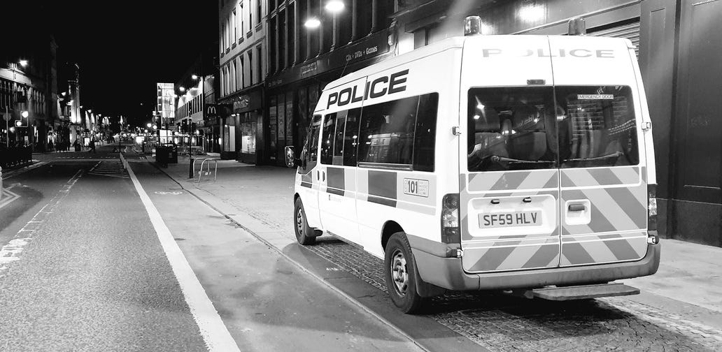 Black and white photograph of a police van in Argyle Street, Glasgow