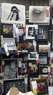 A display of ribbon winning art with the different colored ribbons attached.