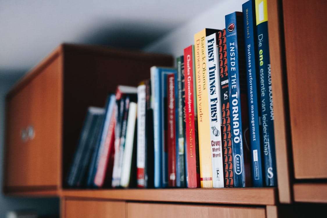 Free Assorted Books on Brown Wooden Shelf Stock Photo