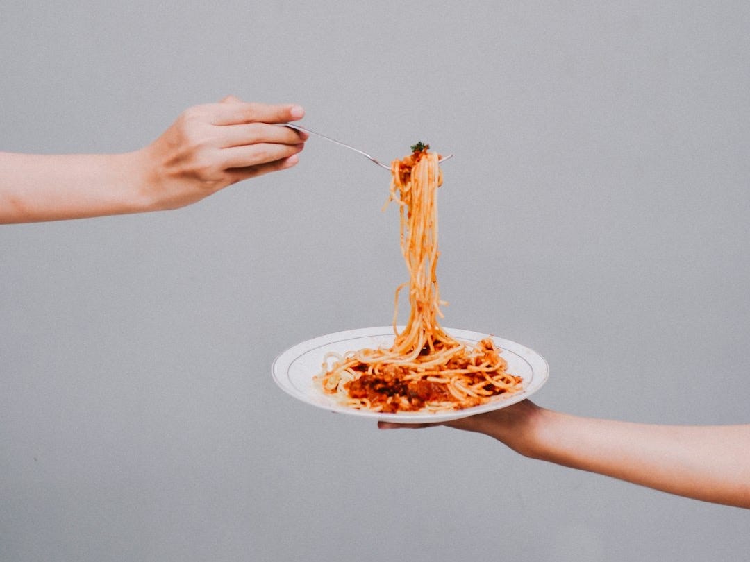 person holding white ceramic plate with food