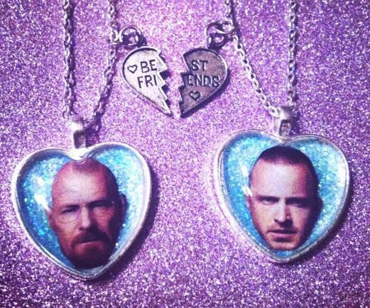This may contain: two heart shaped necklaces with the faces of two men