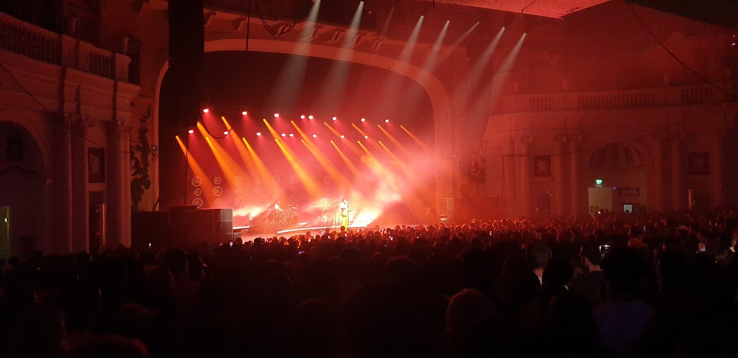 Inside O2 Academy Brixton during a live performance showing the packed crowd and dramatic stage lighting