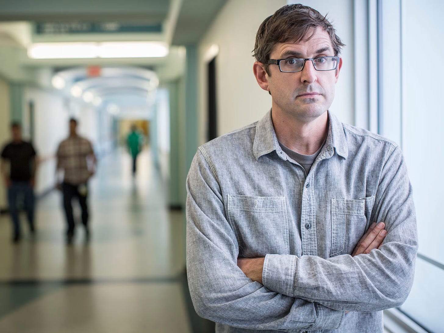Photo of Louis Theroux in corridor with blurred people behind