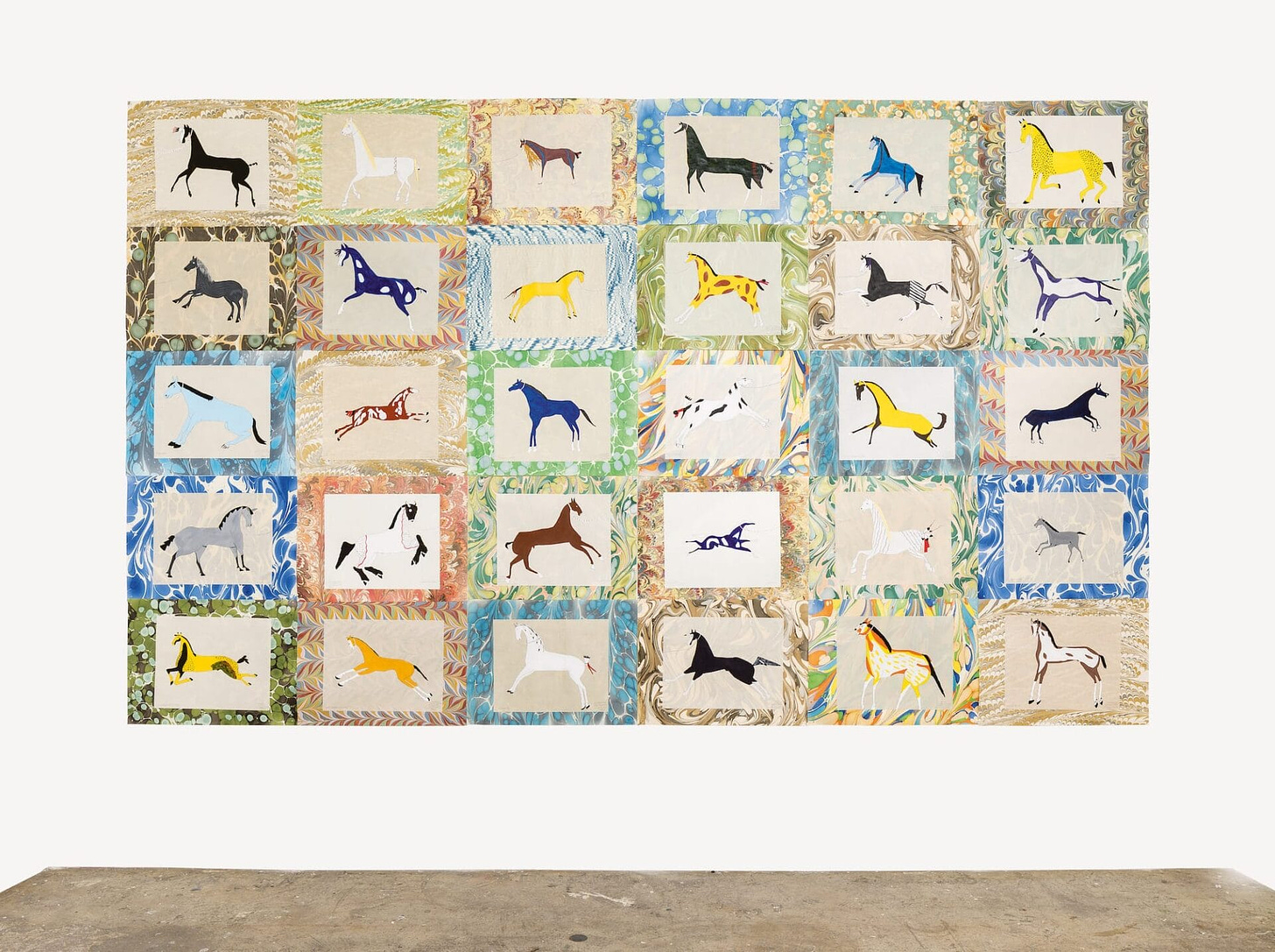 A multicolor quilt with a landscape oriented grid where each square features a different color horse.