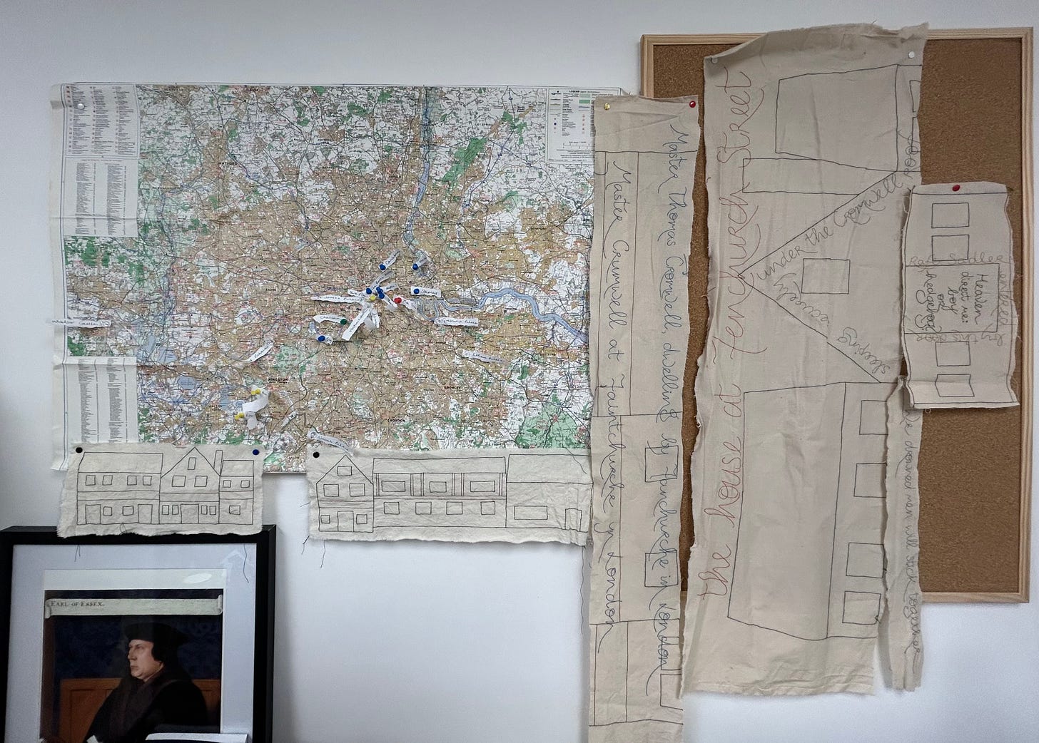 A map with pins showing locations around London; some embroidered images of houses; a portrait of Thomas Cromwell.