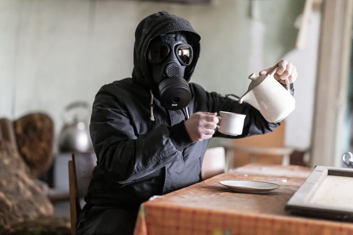 Free Person Pouring Coffee Wearing Gas Mask Stock Photo