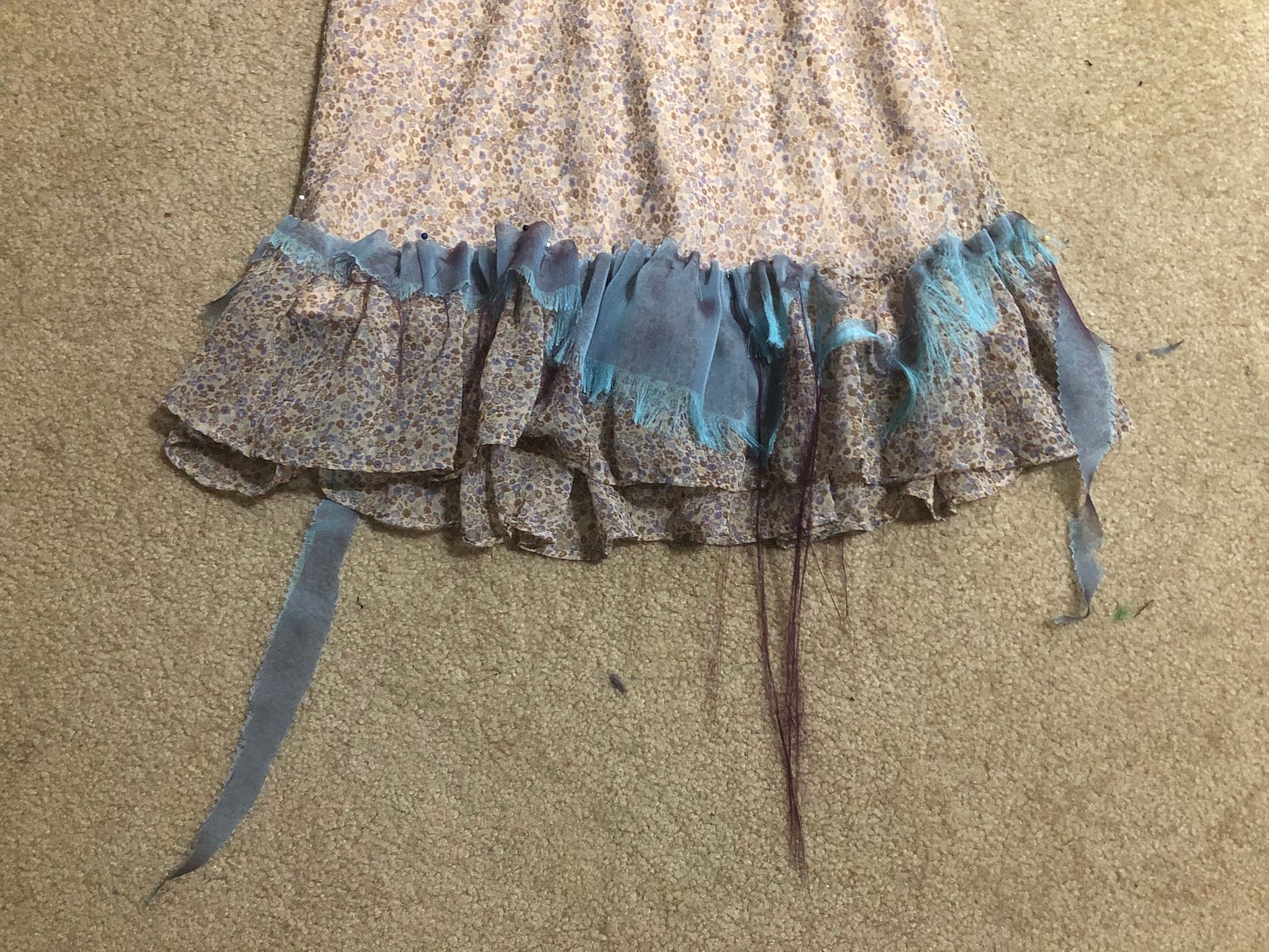 Blue tattered fabric adorns the bottom of a cute floral dress