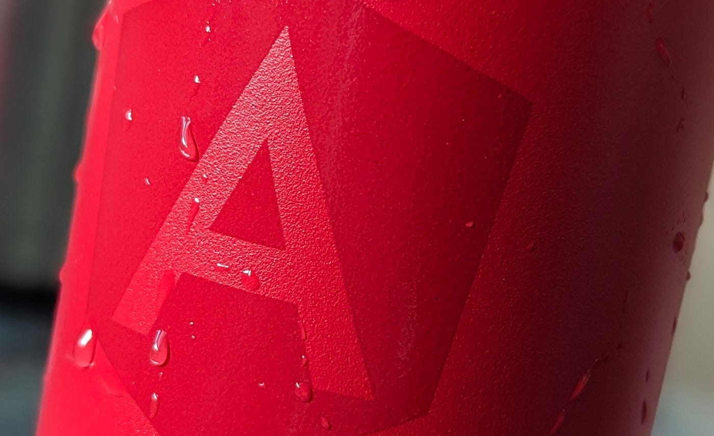 red water bottle with angular logo and droplets of water on it