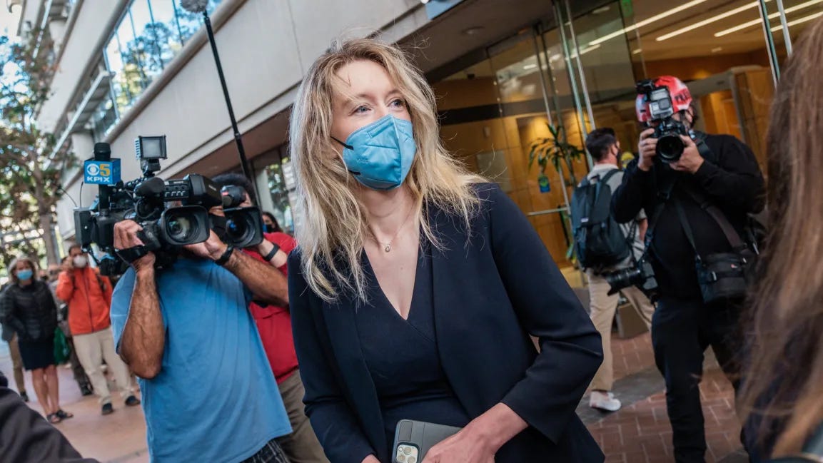 Elizabeth Holmes, the founder and former CEO of blood testing and life sciences company Theranos, arrives for the first day of jury selection in her fraud trial, outside Federal Court in San Jose, California on August 31, 2021. She is wearing some PPE – a blue face mask.