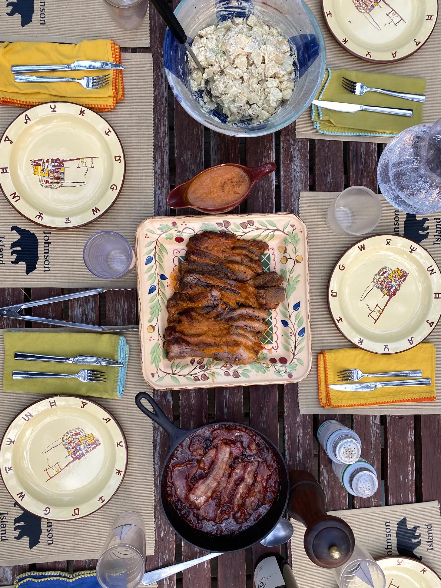 A set table with a platter of BBQ brisket in the center.