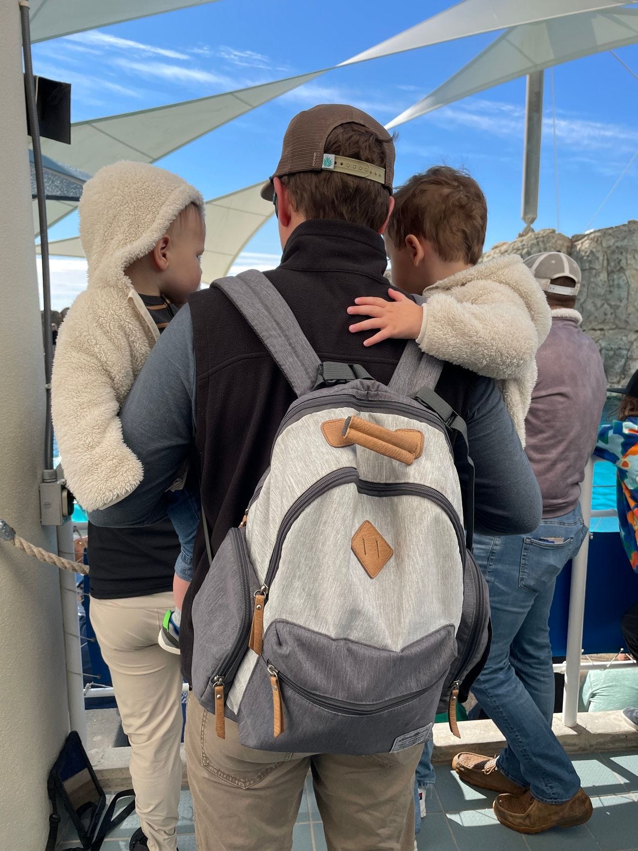 A man holding a child in each of his arms A man holding a child in each of his arms