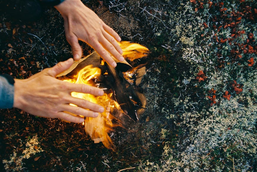 hands hovering over a fire