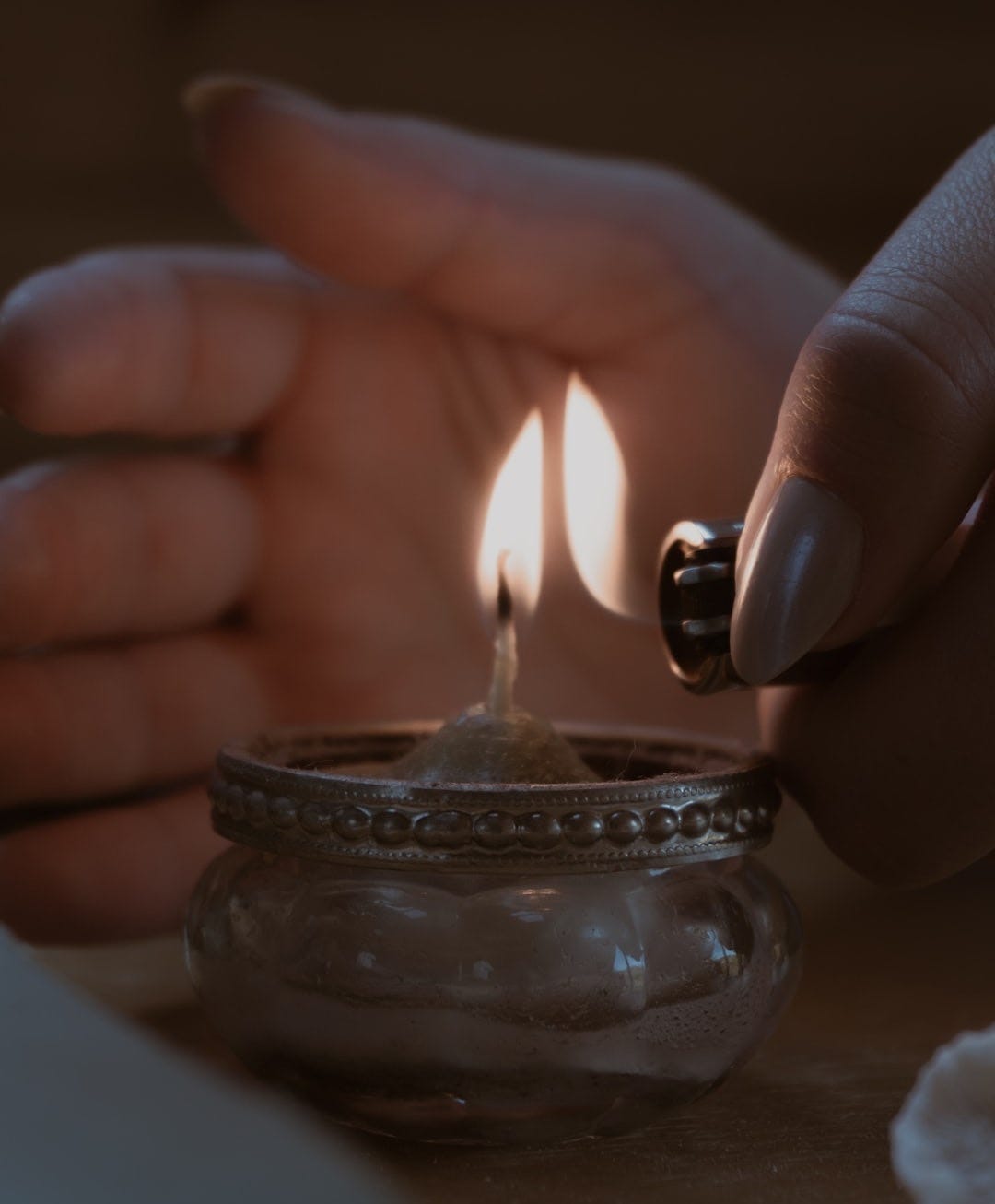 a person lighting a candle on a table