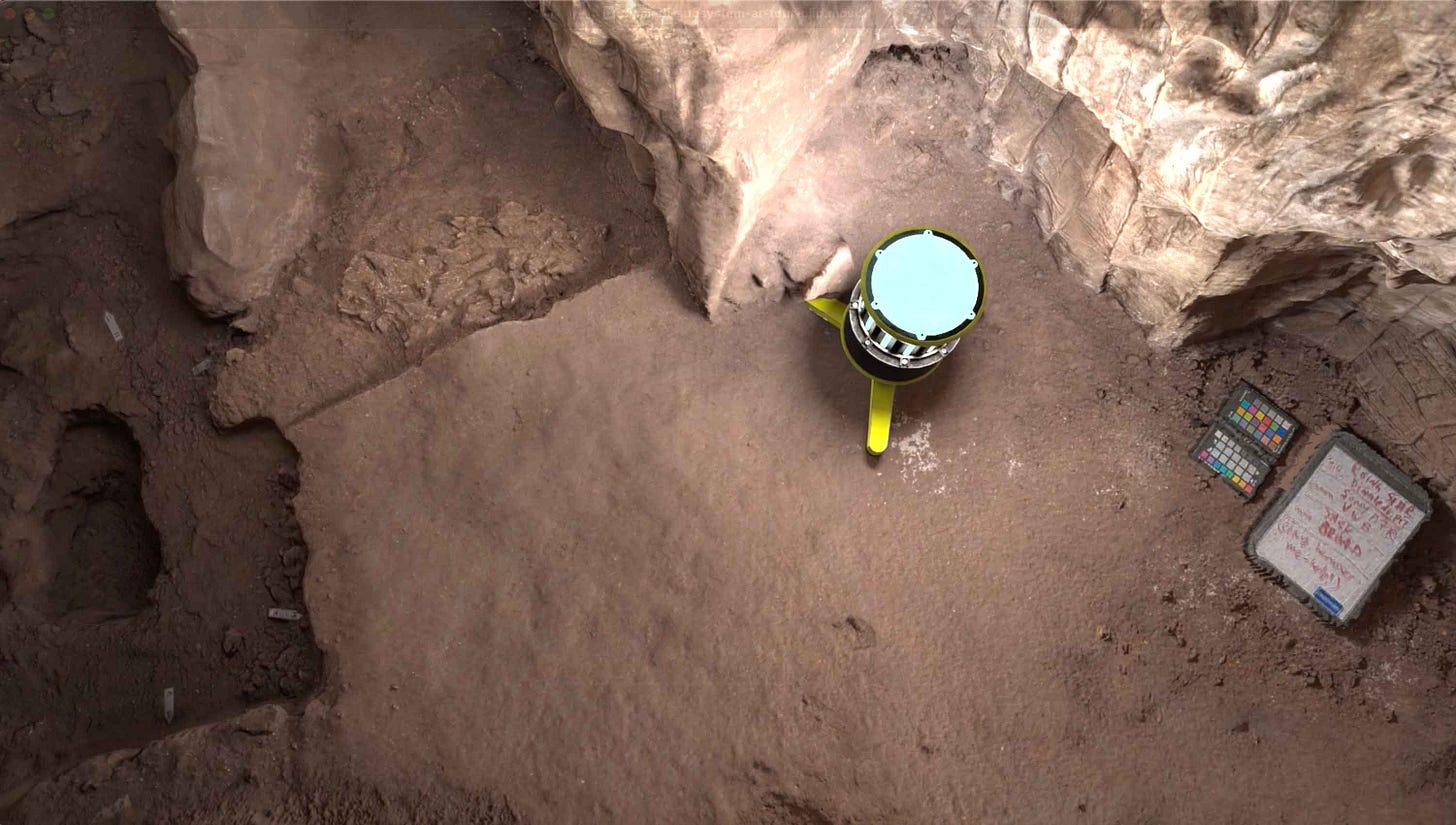 An image of a cave floor with areas of excavation, a lighting unit, and a whiteboard with notes An image of a cave floor with areas of excavation, a lighting unit, and a whiteboard with notes