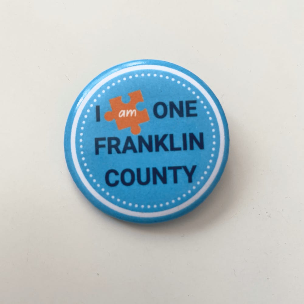 Photo of custom button promoting the One Franklin County project