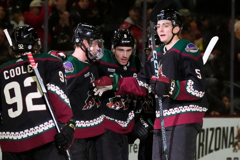 Arizona Coyotes center Nick Schmaltz celebrates after his goal with center Logan Cooley, defensemen Juuso Valimaki, second from left, and Nick Schmaltz during an NHL hockey game.