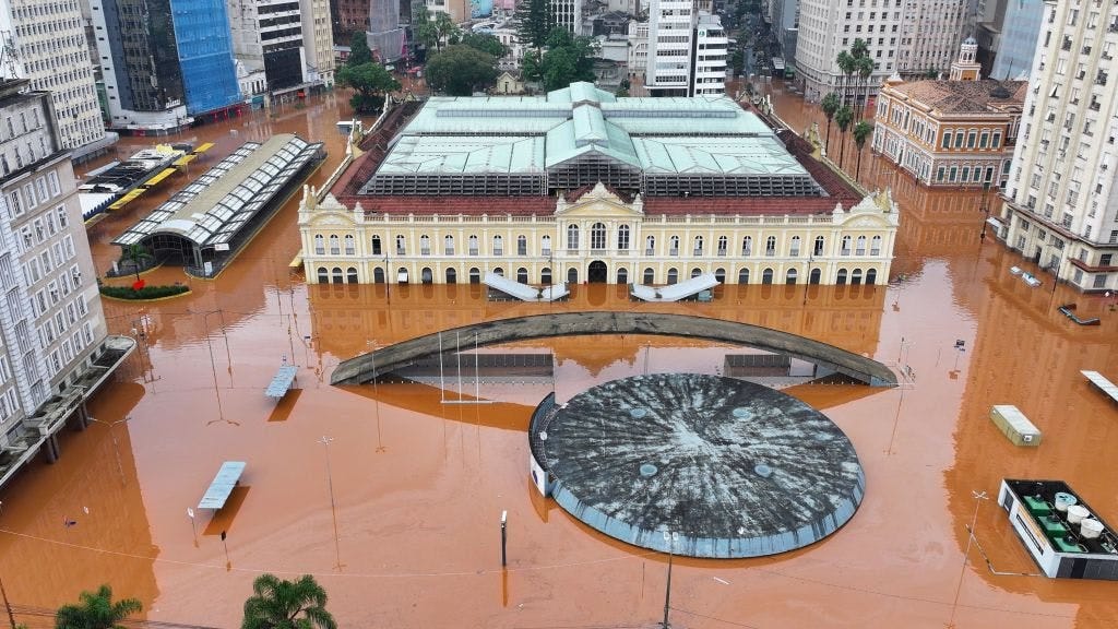 Imagem aérea da estação de ônibus, do mercado público, da estação da Trensurb e dos prédios do centro histórico de Porto Alegre inundados pela água do Guaíba