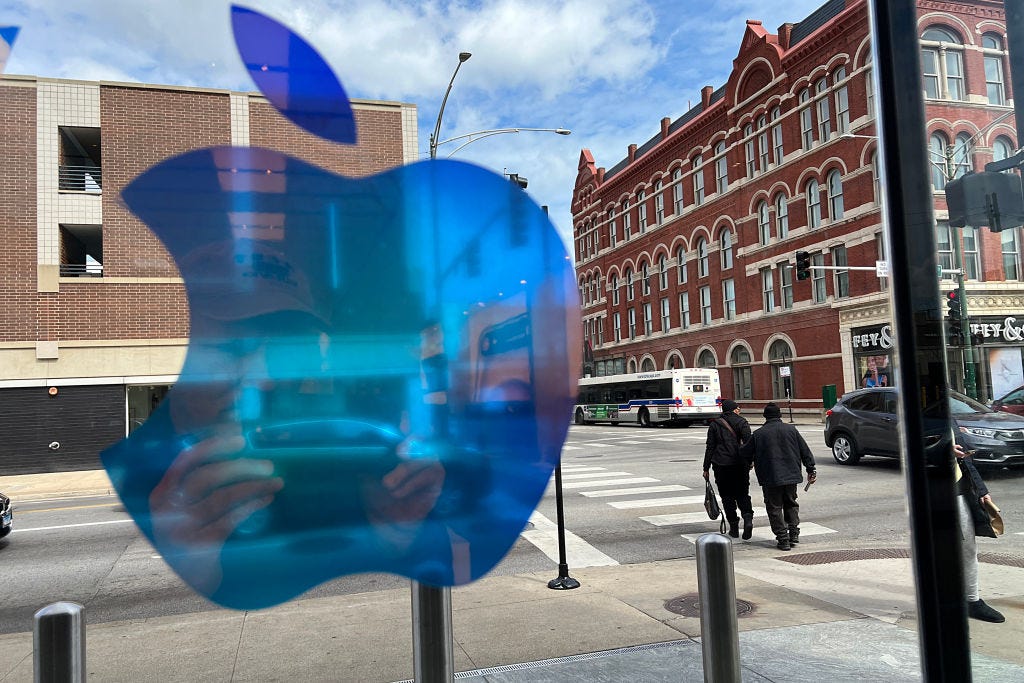 The window of an Apple store looks out on the street.
