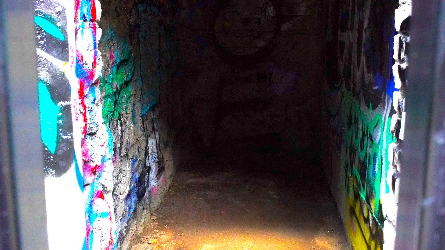 A small dark hole surrounded by bright graffiti. 