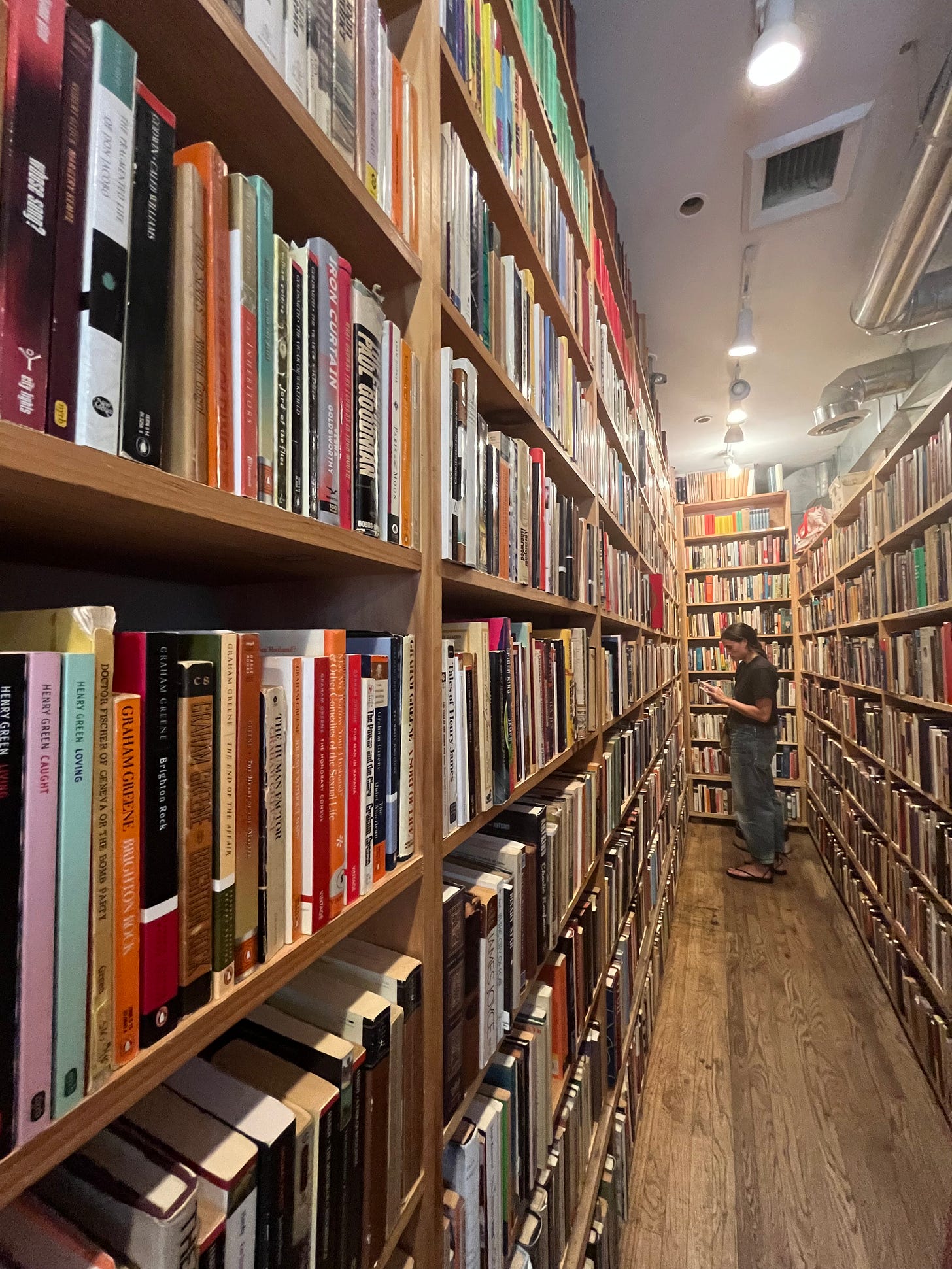 photo of a long aisle covered in bookshelves