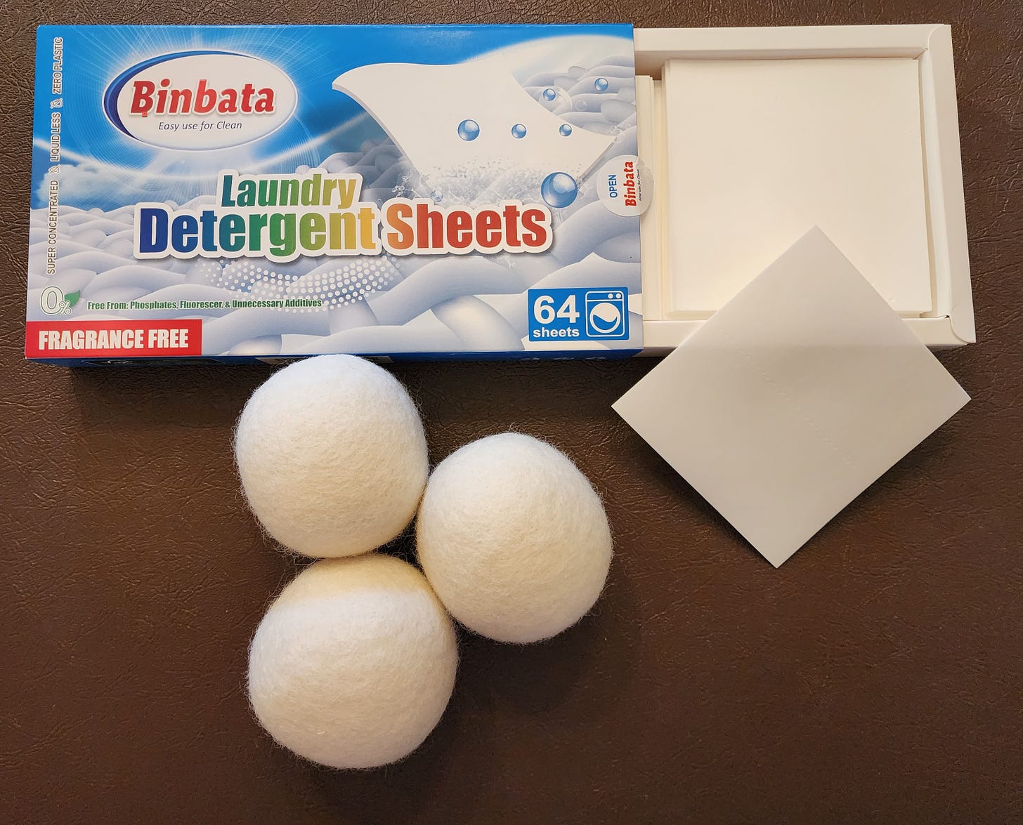 open box of laundry detergent sheets with three white wool dryer balls