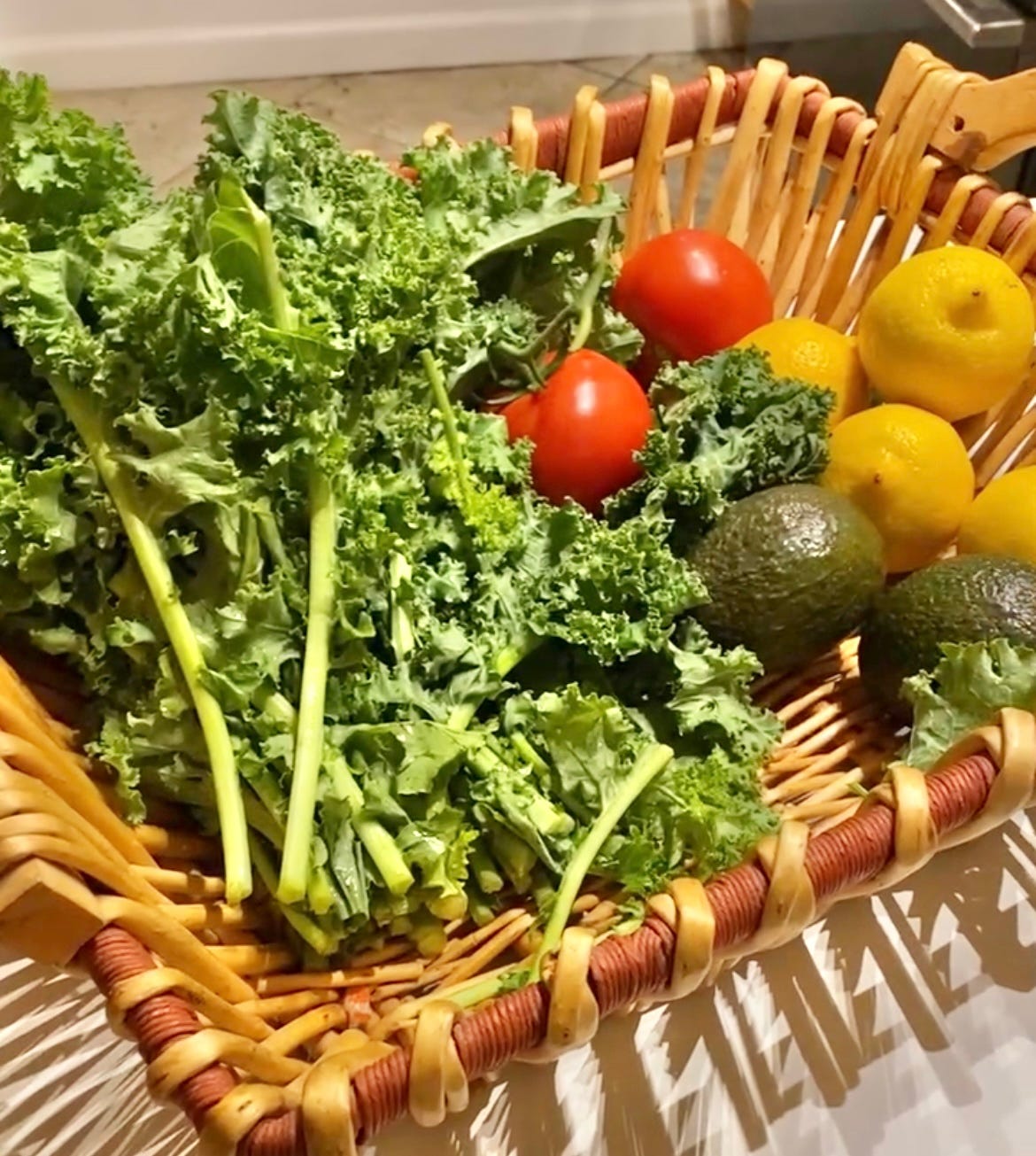Basket of kale, tomatoes and lemons