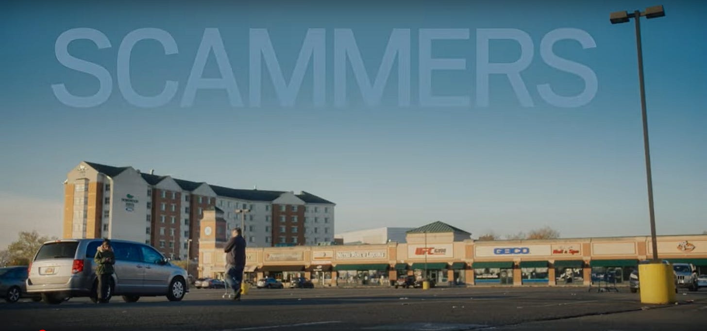 The title short from short film "Scammers" by Carl Kesch. One a cool, sunny day, this landscape shot shows the parking lot of a minimal mall with a six or seven-story hotel in the background. Somewhat in the foreground are a father-daughter pair. Father's about six-feet three and the daughter is about five-foot-five. They're standing next to a minivan. The title short from short film "Scammers" by Carl Kesch. One a cool, sunny day, this landscape shot shows the parking lot of a minimal mall with a six or seven-story hotel in the background. Somewhat in the foreground are a father-daughter pair. Father's about six-feet three and the daughter is about five-foot-five. They're standing next to a minivan.