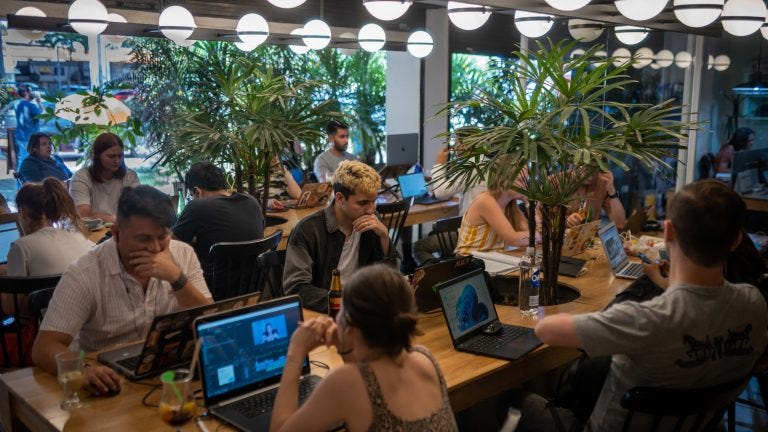A photo showing a crowded co-working space in Colombia, with lots of people working on laptops.