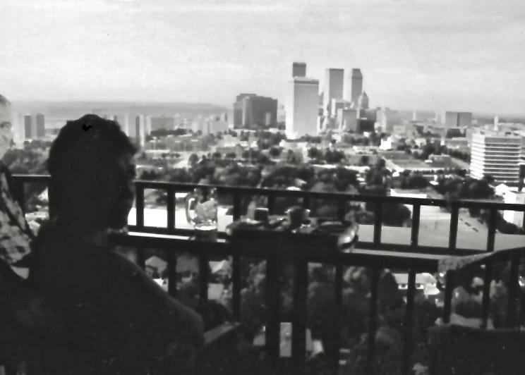 B&W Photo by Sherry Killam Arts of the Author looking over a balcony to the Tulsa skyline.