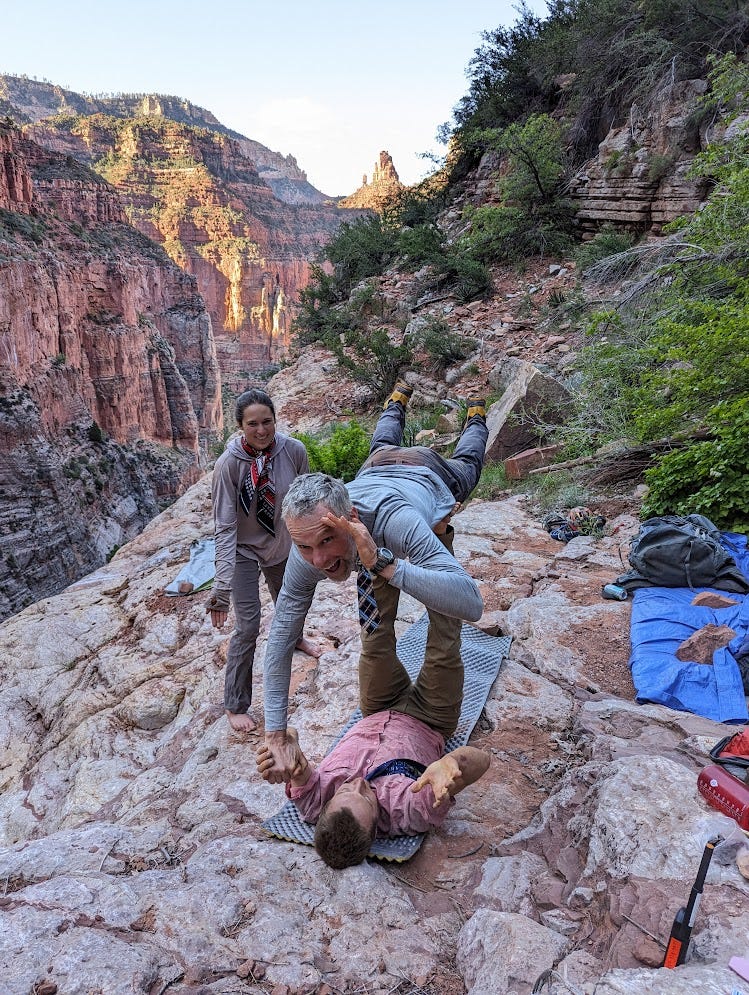 Alex and Stan doing acro yoga. Alex basing, Stan flying, in the bird pose