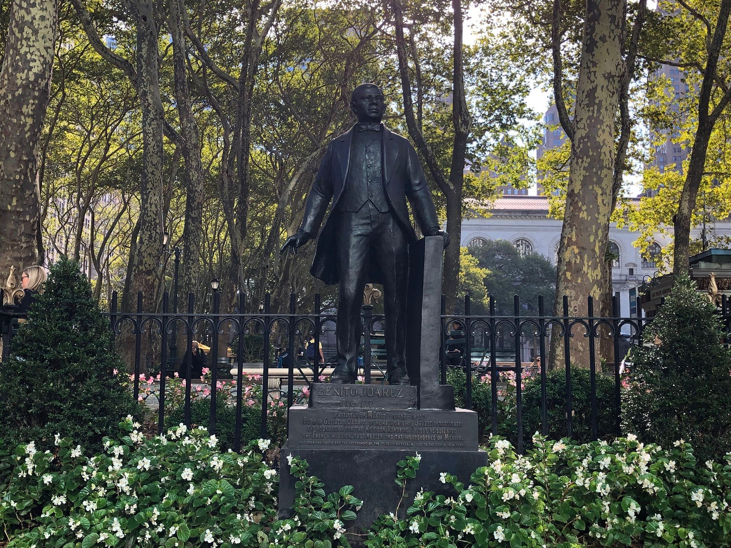 STATUE OF MAN STANDING TALL WITH HAND ON A RAIL