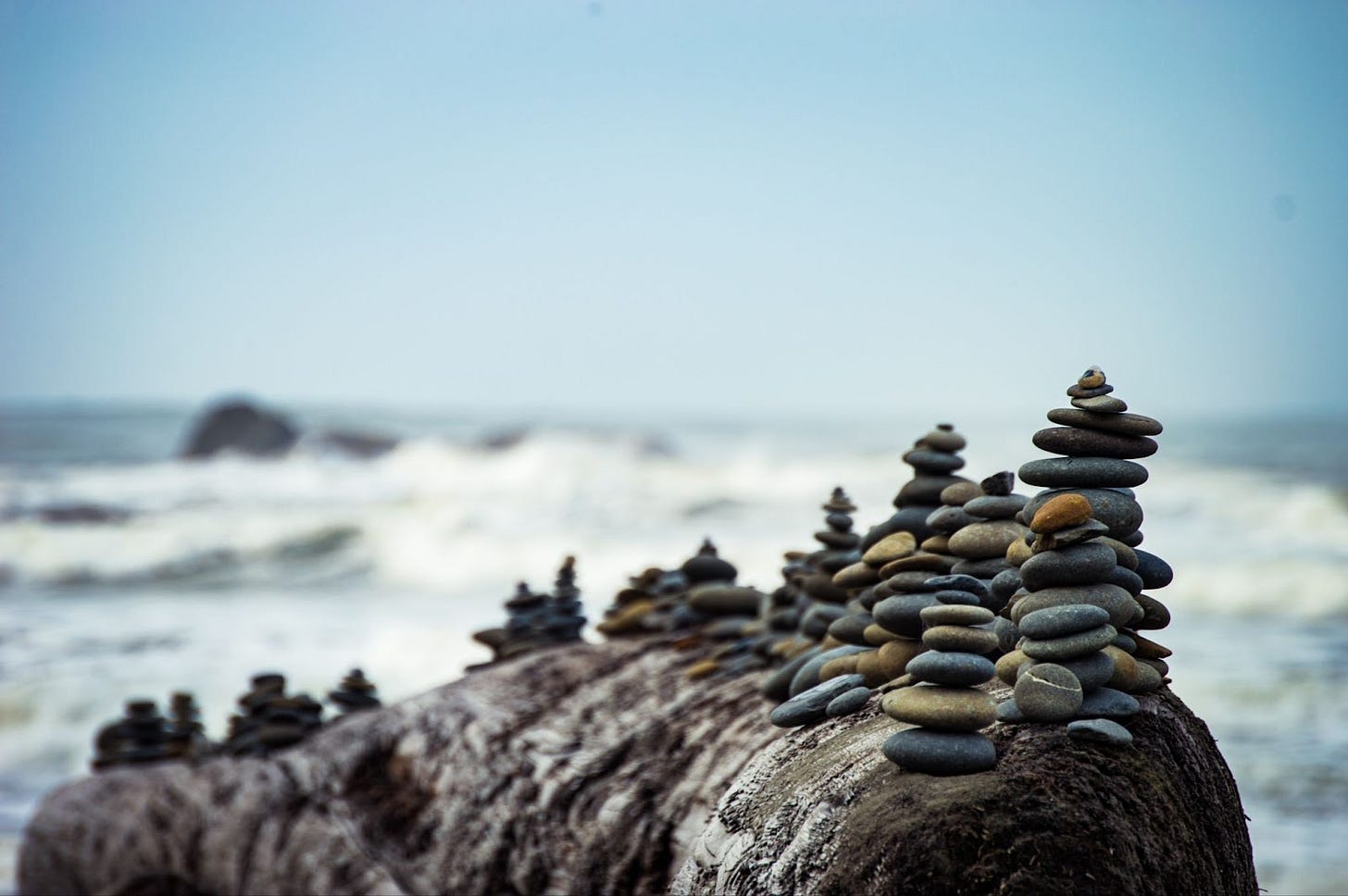 Multiple stacks of rocks on a large rock in along the ocean shore. Multiple stacks of rocks on a large rock in along the ocean shore.