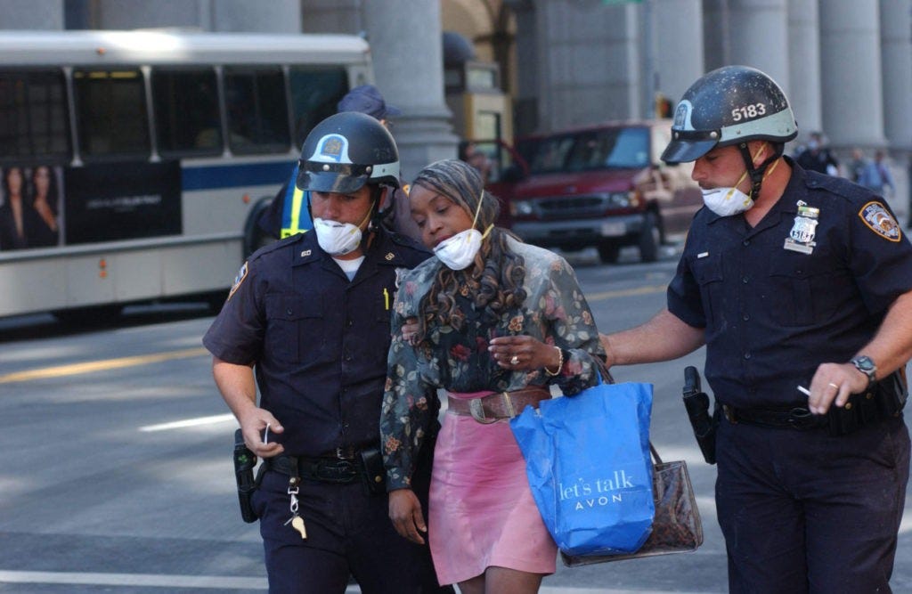 394261 33: ( NEWSWEEK, US NEWS, GERMANY OUT) Police escort a civilian from the scene of the collapse of a tower of the World Trade Center September 11, 2001 in New York City after two airplanes slammed into the twin towers in an alleged terrorist attack. (Photo by Spencer Platt/Getty Images)