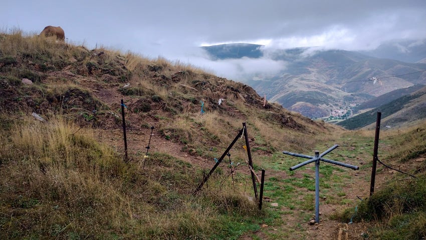 Alambrada con torno y al fondo, en el valle, el pueblo de Busdongo