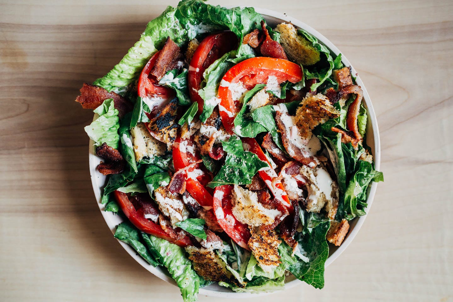 A BLT salad arranged in a bowl on a table. 