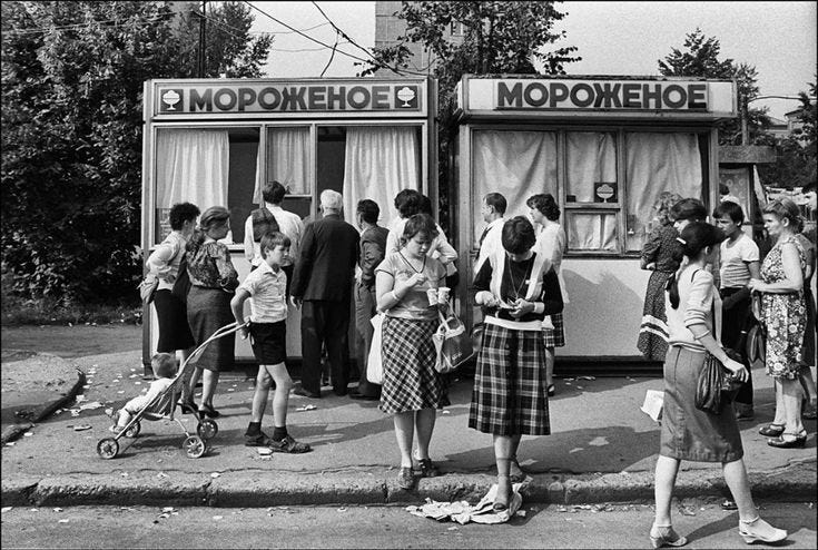 This may contain: many people are standing in front of an old phone booth