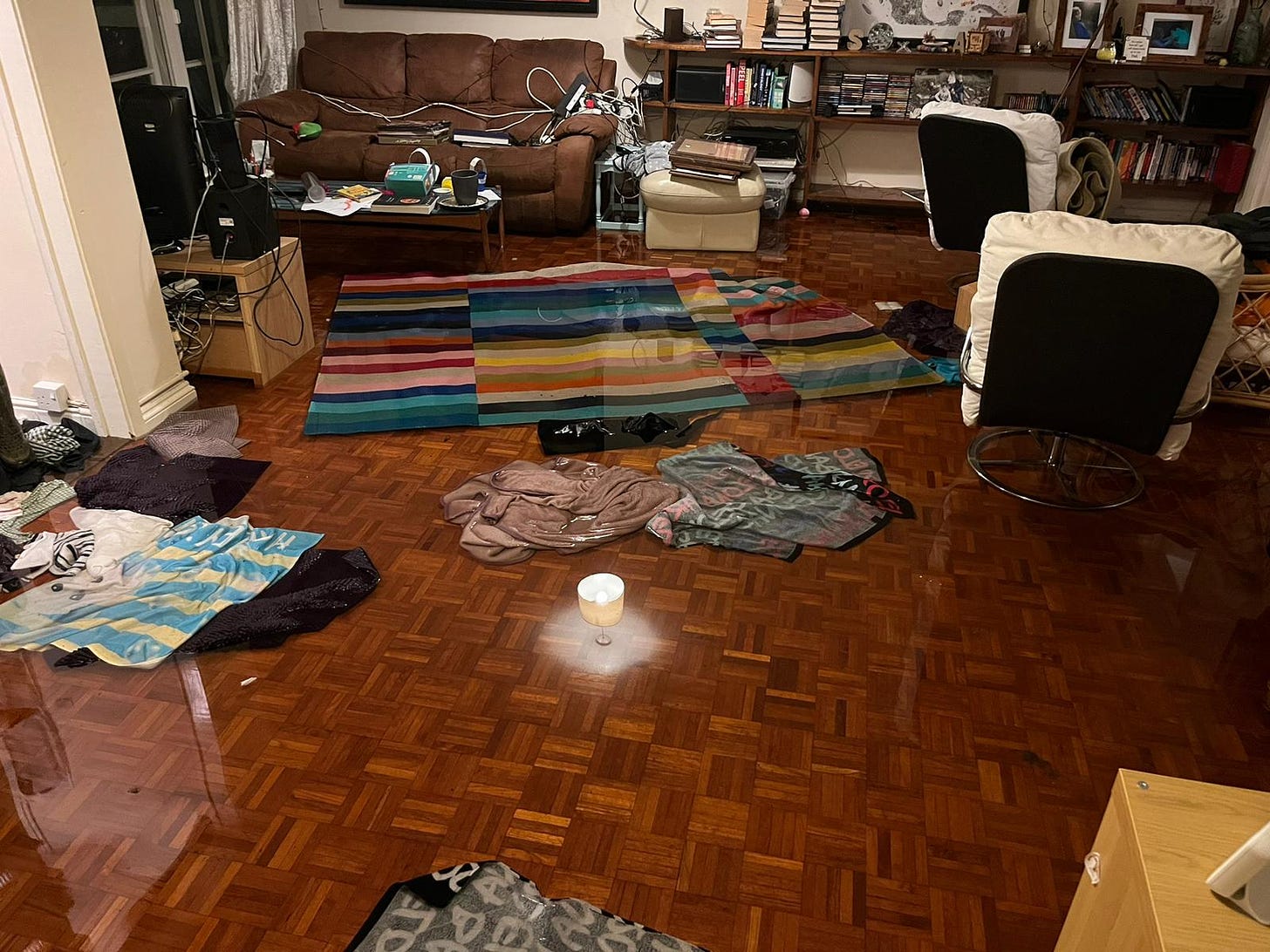 Spen's living room under 2 inches of water, towels and mats floating by