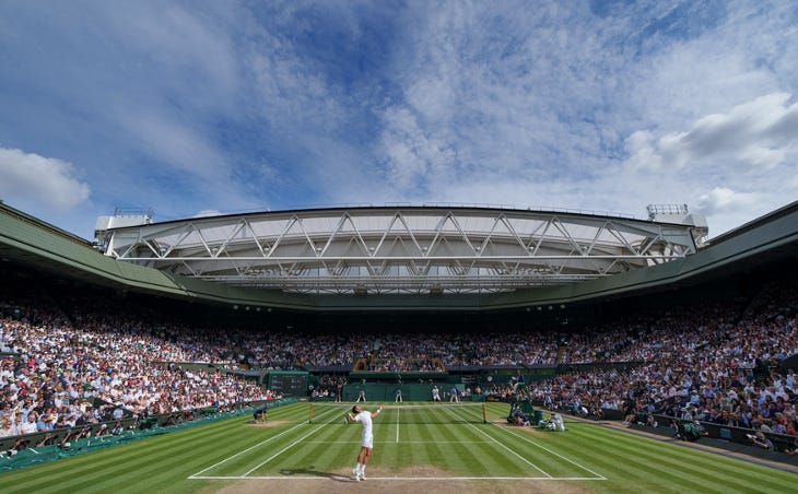 Tennis taking place on Centre Court at Wimbledon