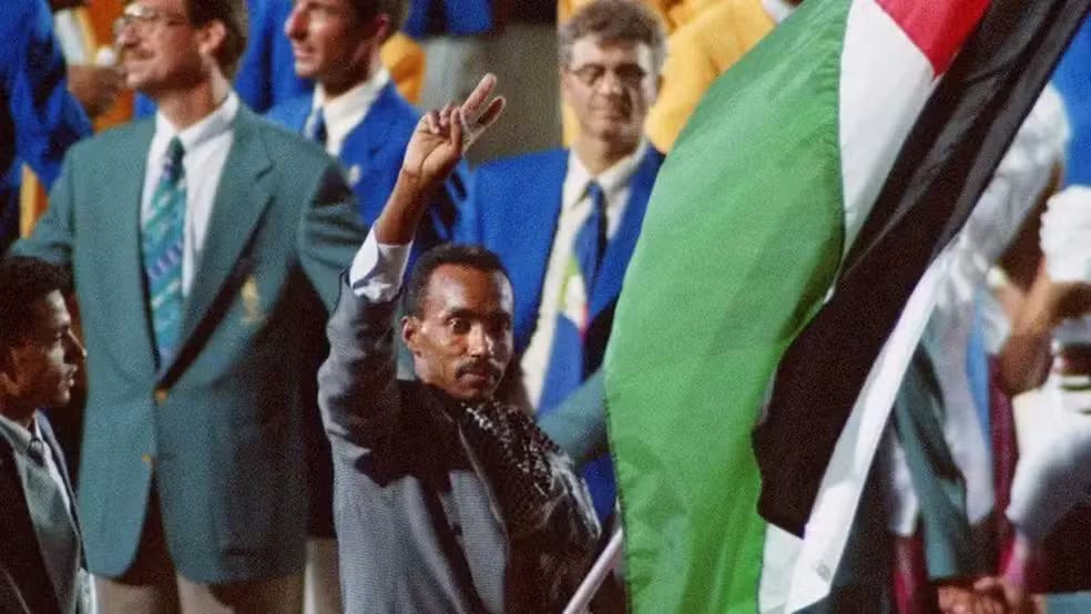 Majed Abu Maraheel com a bandeira palestina nos Jogos de Atlanta, em 1996. O ex-atleta olímpico morreu em Gaza em junho deste ano.