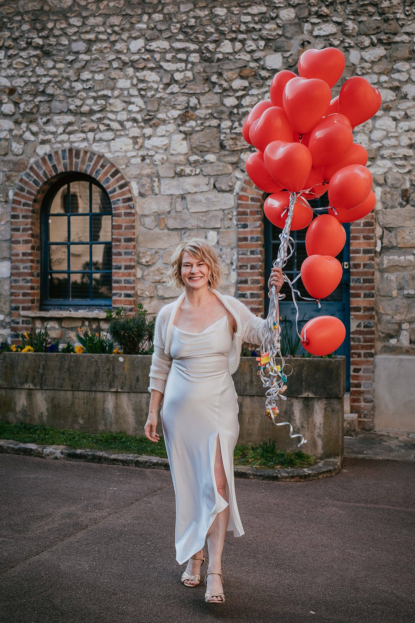 A bride poses with a balloon bouquet at her wedding