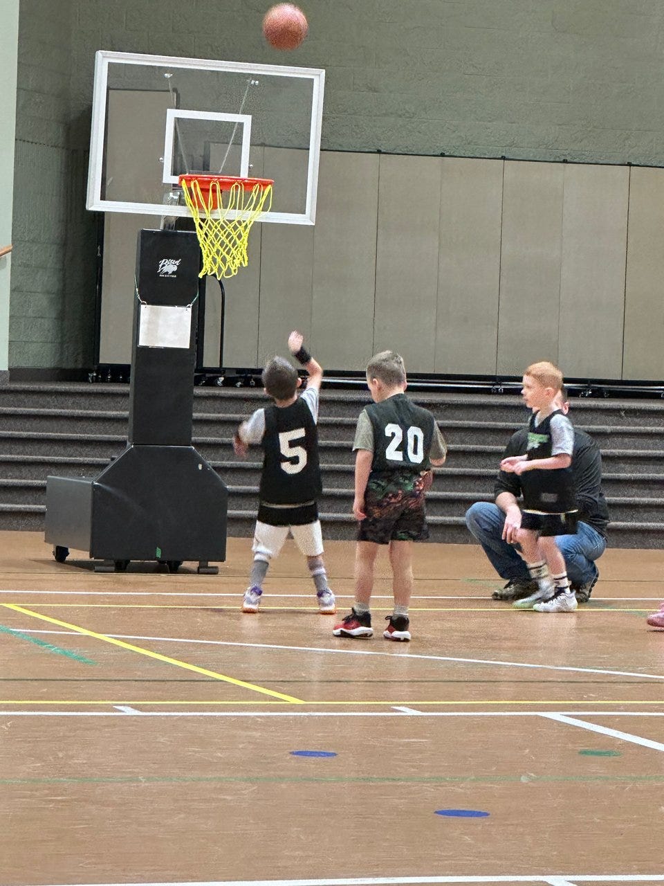A group of young kids playing basketball.